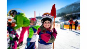 Skikind im Kindergartenskikurs lächelt in die Kamera