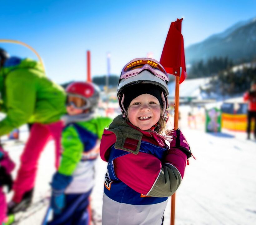 Skikind im Kindergartenskikurs lächelt in die Kamera